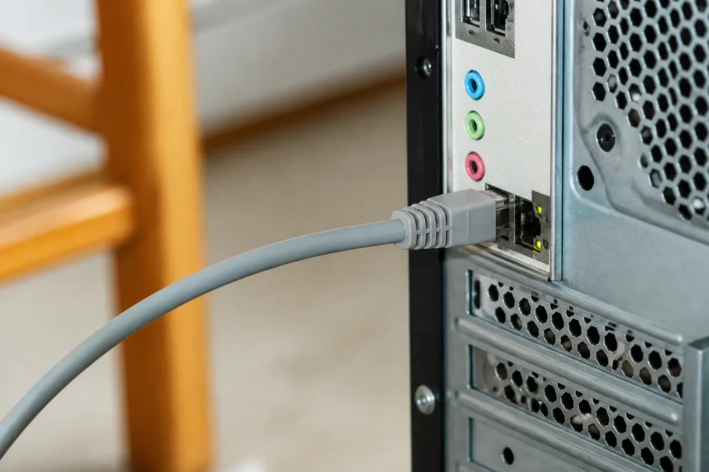 Cable Ethernet gris branche sur un ordinateur de bureau