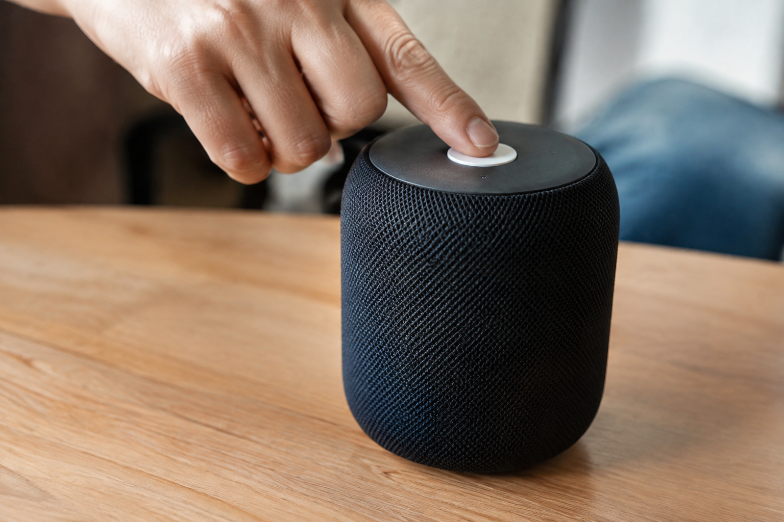 Main appuyant bouton blanc sur enceinte noire