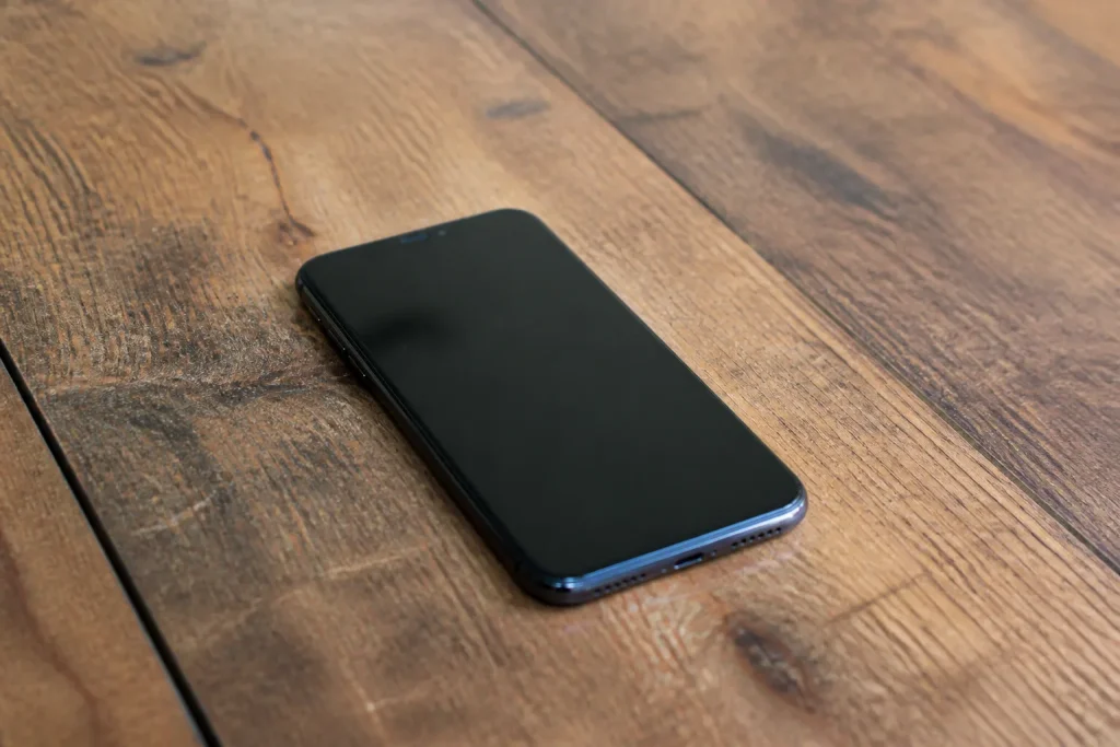 Smartphone noir pose sur une table en bois